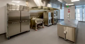 Commercial refrigeration units and stainless steel kitchen equipment in a modern professional food service facility.