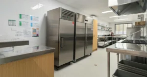 Commercial refrigeration systems and stainless steel equipment inside a clean, professionally organized kitchen.
