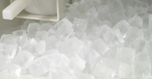 Fresh ice cubes dispensed from a commercial ice machine during routine service.